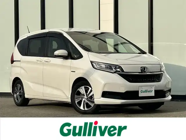 ホンダ フリード ハイブリット G ホンダセンシング 大阪府 2021(令3)年 4.9万km プラチナホワイトパール ホンダセンシング/ワンオーナー/純正9インチナビ/・フルセグTV/BT/USB/バックカメラ/11.6インチフリップダウンモニター/両側パワースライドドア/追従型クルーズコントロール/前ドライブレコーダー/ETC/純正フロアマット/ハーフレザーシート/革巻ハンドル/後席ロールサンシェード/純正15インチAW/取説・保証書/スペアキー/LEDヘッド