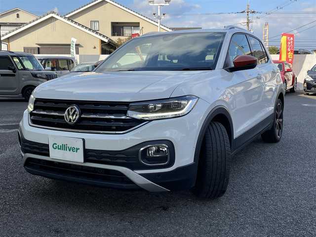 フォルクスワーゲン Ｔ－クロス TSI 1stプラス 大分県 2020(令2)年 3.3万km ピュアホワイト ハーフレザーシート/純正メモリーナビ/　CD/DVD/BT/USB/ラジオ/フルセグ/バックカメラ/ETC2.0/レーンキープアシストシステム/スタティックコーナリングライト /デイタイムランニングライト/ブラインドスポットディテクション（後方死角検知機能）/ドライバー疲労検知システム/パークディスタンスコントロール/リヤトラフィックアラート/プロアクティブ・オキュパント・プロテクション/ESC（エレクトロニック・スタビリティ・コントロール）/ドライブレコーダー（HDR360G)/プッシュエンジン/クリアランスソナー/アイドリングストップ/パーキングアシスト/ステアリングスイッチ/チルステアリング/レベライザー/ウィンカーミラー/ブライングスポット/オートハイビーム/スマートフォンワイヤレスチャージング /リアトラックアシスト/アダプティブクルーズコントロール/純正マット/プライバシーガラス/ルーフレール/保証書/取扱説明書