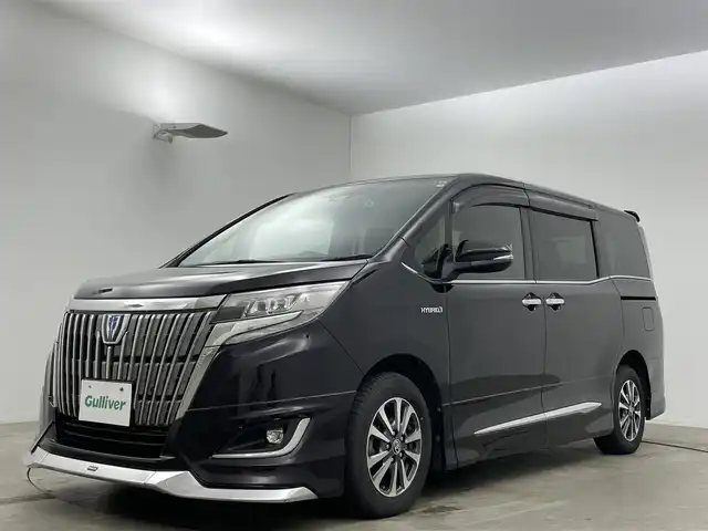 トヨタ エスクァイア ハイブリッド Gi 岡山県 2020(令2)年 7万km ボルドーマイカメタリック 純正9インチメモリナビゲーション		/【フルセグ/Bluetooth/DVD/MSV】/１２．１インチフリップダウンモニター/モデリスタエアロ		/バックカメラ		/純正15inアルミホイール+サマータイヤ：装着		/クルーズコントロール		/ビルトインETC		/LEDヘッドライト（AUTO機能付き）		/シートヒーター		/横滑り防止機能		/衝突軽減システム		/車線逸脱防止システム		/社外ドライブレコーダー				/プッシュスタート		/コーナーセンサー				/純正フロアマット		/新車保証書		/取扱説明書		/スペアキー×１