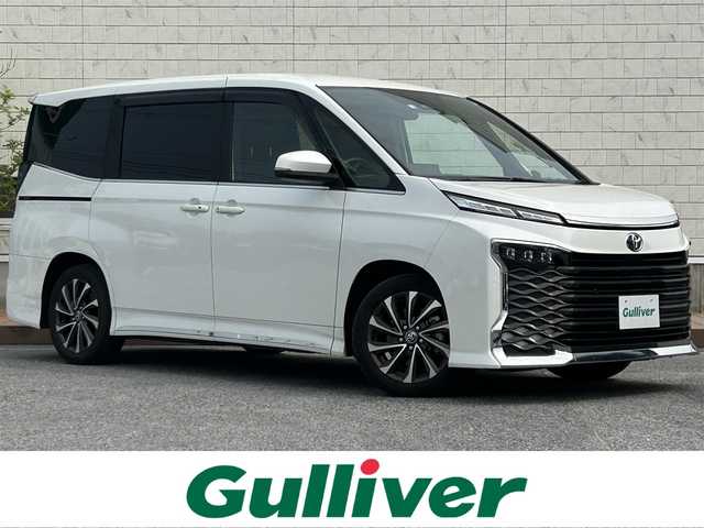 トヨタ ヴォクシー S－Z 滋賀県 2022(令4)年 3.7万km ホワイトパールクリスタルシャイン ガソリン/2WD(FF)/CVT/フリップダウンモニター/両側パワースライドドア/10.5インチディスプレイオーディオ/(FM/AM/フルセグ/Bluetooth)/バックカメラ/ETC/ドライブレコーダー/ＴｏｙｏｔａＳａｆｅｔｙSｅｎｓｅ/・プリクラッシュブレーキアシスト		/・踏み間違い防止アシスト/・トヨタチームメイト（アドバンストドライブ）/・レーンキープアシスト/・緊急時操舵支援（アクティブ操舵機能付）/・フロントクロストラフィックアラート（ＦＣＴＡ）/・ブラインドスポットモニター（ＢＳＭ）/・安心降車アシスト（ドアオープン制御付）（ＳＥＡ）/・パーキングサポートブレーキ/・標識検知機能	/デジタルインナーミラー/運転席・助手席・2列目シートヒーター/2列目シートオットマン/電動リアゲート/電動格納ミラー/電動パーキング/ブレーキホールド/革巻きステアリング/ステアリングスイッチ/オートライト/LEDヘッドライト/フロントフォグ/フルオートエアコン/プッシュスタート/スマートキー/純正フロアマット/ドアバイザー