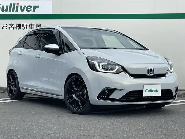 ホンダ フィット e:HEVリュクス 東京都 2020(令2)年 5.2万km プレミアムサンライトホワイトパール wedssport SA25R 17インチ/CUSCO 車高調/純正Gathersナビ/【フルセグ/Bluetooth】/バックカメラ/おくだけ充電/前後ドライブレコーダー/レーダークルーズコントロール/ステアリングヒーター/シートヒーター/コーナーセンサー/ETC//ワンオーナー/保証書/取説/スペアキー/純正サス、純正AW車載