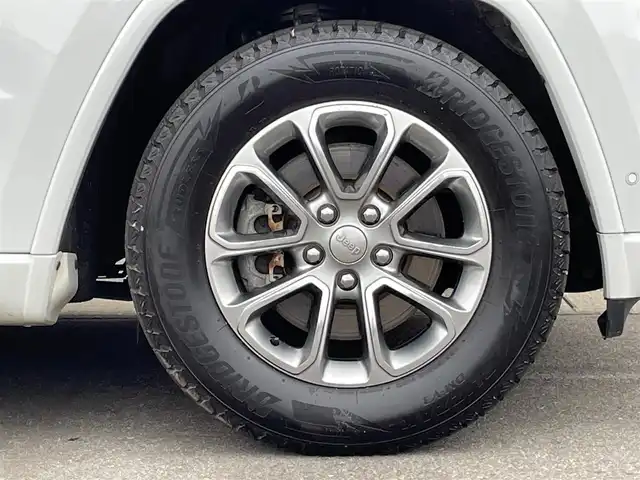 クライスラー・ジープ ジープ グランドチェロキー アルティテュード 青森県 2019(令1)年 4.3万km ブライトホワイト /４WD/黒ハーフレザーシート/D席パワーシート/前席シートヒーター/純正エアサス/純正SDナビフルセグTV/（ Bluetooth/USBx2 ）/バックカメラ/DSRC・ETC/革巻きステア/ノブ/パドルシフト/ミラーヒーター/電動チルトステア/電格調整ミラー/クルーズコントロール/ブラックルーフレール/サイドステップ/ヒルディセントコントロール/ブレーキアシスト/パーキングアシスト/トラクションコントロール/前後バンパーソナー/ヘットライトウオッシャー/前後フォグランプ/前後ドラレコ/純正HID/アイドリングストップ/横滑り防止機能/W/サイド/カーテン/ニーエアバッグ/ABS/スマートキーｘ２/保証書/取説