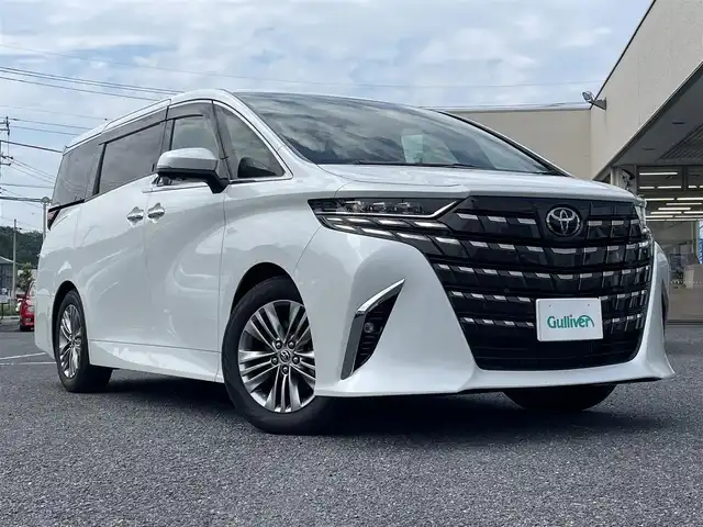 トヨタ アルファードハイブリット Z 栃木県 2024(令6)年 1.5万km プラチナホワイトパールマイカ ワンオーナー/左右独立ムーンルーフ/トヨタセーフティセーフティセンス/ ・プリクラッシュセーフティ/ ・レーントレーシングアシスト/ ・レーンディパチャーアラート/ ・レーダークルーズコントロール/ ・ブラインドスポットモニター/ ・アダプティブハイビームシステム/ ・オートマッチクハイビーム/ ・ロードサインアシスト/ ・ドライバー異常時対応システム/ ・発進遅れ告知機能/ ・プロアクティブドライビングアシスト/ ・緊急時操舵支援/ ・フロントクロストラフィックアラート/ ・レーンチェンジアシスト/パノラミックビューモニター/両側パワースライドドア/パワーバックドア/純正14インチディスプレイオーディオ[ナビ付]/[フルセグ/AM/FM/BT/USB/HDMI/ Miracast]/ビルトインETC2.0/ステアリングヒーター/前席/2ndパワーシート/前席/2ndシートヒーター/前席/2ndシートベンチレーション/後席用パワーサイドサンシェード/2ndシートオットマン/前後ドライブレコーダー/コーナーセンサー/AC１００V/3眼LEDヘッドライト/フォグランプ/置くだけ充電/デジタルインナーミラー