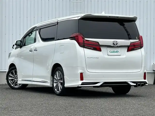 トヨタ アルファード S タイプゴールドⅡ 熊本県 2021(令3)年 2.1万km ホワイトパールクリスタルシャイン 純正ディスプレイオーディオ/・ナビキット/・フルセグTV/・AM/FM/USB/Bluetooth/・Miracast/・T-Connect/Smart DeviceLink/トヨタセーフティーセンス/・レーントレーシングアシスト/・クリアランスソナー/・パーキングサポートブレーキ/・プリクラッシュセーフティー/・ブラインドスポットモニター/・リアクロストラフィックアラート/・ロードサインアシスト/ビルトインETC2.0/ドライブレコーダー（前方）/ツインムーンルーフ/純正後席モニター/オットマン/ボタン式サイドブレーキ/ホールドブレーキ/デジタルインナーミラー/ステアリングスイッチ/革巻きステアリング/ウィンカーミラー/電動格納ミラー/ナノイー/MODELLISTAエアロパーツ/テレビキャンセラー/PWR DOOR OFFスイッチ/フォグランプ/ECOモード/純正フロアマット