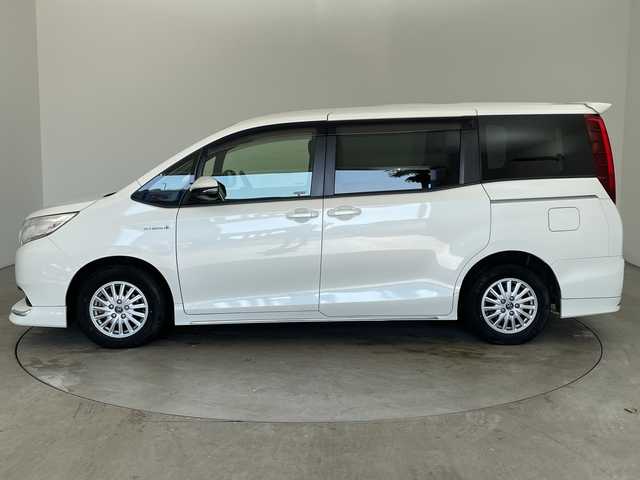 トヨタ ノア ハイブリッド X 兵庫県 2014(平26)年 8.4万km ホワイトパールクリスタルシャイン ・純正9インチナビ（NSZT-Y64T）/CD/DVD/SD/Bluetooth/TV/・バックカメラ/・ビルトインETC/・社外フリップダウンモニター/・ステアリングスイッチ/・フロント、リアエアロ/・LEDヘッドライト/・オートライト/・助手席側パワースライドドア/・純正アルミホイール/・純正フロアマット/・スマートキー