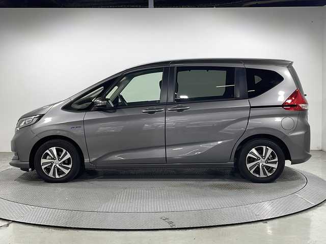 ホンダ フリード ハイブリット G ホンダセンシング 広島県 2021(令3)年 1.4万km スーパープラチナグレーメタリック 純正９型ナビ　/両側パワースライドドア　/後席モニター　/レーダークルーズコントロール　/フルセグ　/バックカメラ　/レーンキープアシスト　/衝突軽減ブレーキ　/コーナーセンサー　/オートライト　/ドラレコ　/ETC/純正15インチアルミホイール（185/65/R15)/エアバック（運転席/助手席）