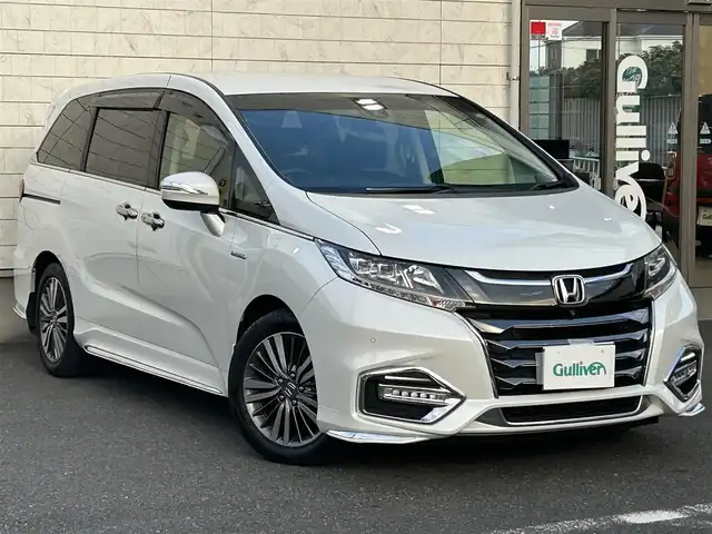ホンダ オデッセイ ハイブリッド 埼玉県 2019(平31)年 3.9万km プラチナホワイトパール 純正ナビ（AM/FM/フルセグTV/BT）/Honda SENSING/・衝突軽減ブレーキ/・路外逸脱抑制機能/・先行車発進お知らせ機能/・アダプティブクルーズコントロール/・車線維持支援システム/・ブラインドスポットインフォメーション/B/F/S/全周囲カメラ/コーナーセンサー前後/両側パワースライドドア/ハーフレザーシート/前席パワーシート/前席シートヒーター/ビルトインETC2.0/純正ドライブレコーダー（F）/電動パーキングブレーキ/純正LEDヘッドライト/純正17インチAW/純正フロアマット/ドアバイザー/AC100V充電/プッシュスタート/スマートキー/スペアキー1本/車両/ナビ取扱説明書/保証書