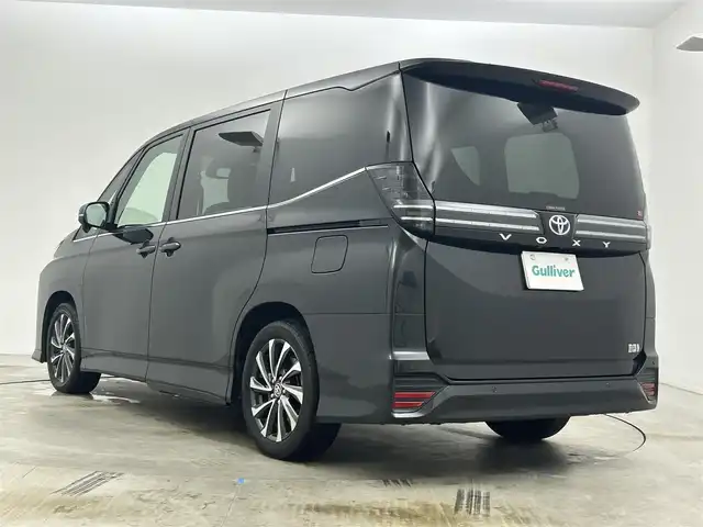 トヨタ ヴォクシー ハイブリッド S－Z 岡山県 2024(令6)年 1.9万km グリッターブラックガラスフレーク 快適利便パッケージ/ハーフレザーシート/純正10.5インチディスプレイオーディオ/　「ナビ/フルセグ/Bluetooth/DVD/ Carplay」/ブラインドスポットモニター/バックカメラ/ユニバーサルステップ（左回りのみ）/追従型クルーズコントロール/オートハイビーム/LEDヘッドライト/ビルトインETC2.0/両側パワースライドドア/シートヒーター(1列目/2列目)/衝突軽減ブレーキシステム/車線逸脱防止システム/横滑り防止装置/純正17インチアルミホイール/コーナーセンサー（前後）/純正フロアマット/ステアリングスイッチ/プッシュスタート/スマートキー×1