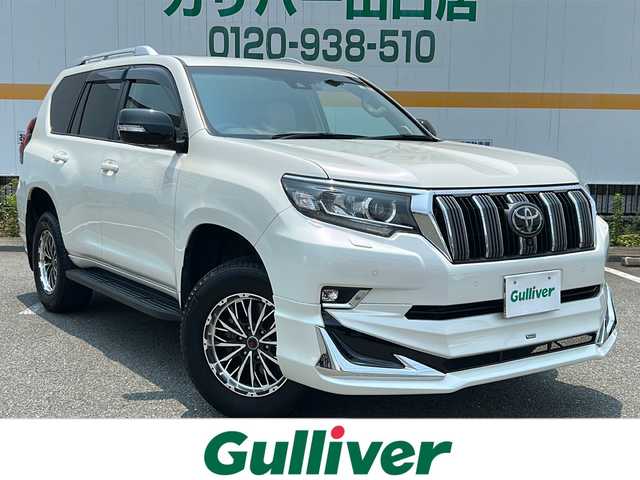 トヨタ ランドクルーザー プラド TX Lパッケージ 山口県 2023(令5)年 3.7万km ホワイトパールクリスタルシャイン ワンオーナー/サンルーフ/純正ナビ/BT/USB/Miracast/全周囲カメラ/ベージュ革シート/前席パワーシート/シートヒーター/エアシート/サードシート電動収納/純正LEDヘッドライト/純正フォグランプ/オートライト/オートハイビーム/社外１７インチアルミホイール/モデリスタエアロ/革巻きステアリング/ステアリングスイッチ/クルーズコントロール/衝突被害軽減ブレーキ/LKA/BSM/横滑り防止/コーナーセンサー/ルーフレール/スマートキー×２/純正フロアマット/純正ドアバイザー/ビルトインETC2.0/電動格納ウインカードアミラー(オート機能付き)