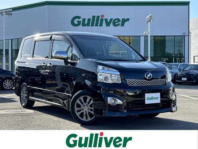 トヨタ ヴォクシー ZS 煌Z 愛媛県 2013(平25)年 9万km ブラック 禁煙車/登録時走行距離89280km/純正ナビ/CD/DVD/TV/Bluetooth/バックカメラ/ビルトインETC/フロントドライブレコーダー/両側パワースライドドア/ハーフレザーシート/回転式セカンドシート/リヤエアコン/オートライト/キセノンヘッドライト/フォグランプ/MTモード付AT/スマートキー