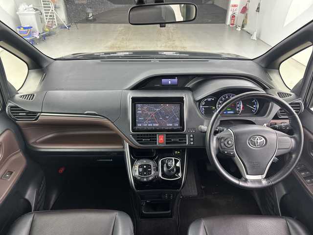 トヨタ エスクァイア ハイブリッド Gi 愛知県 2015(平27)年 6.8万km ブラック 禁煙車/純正9インチナビ/(Bluetooth CD DVD SD FM AM フルセグTV)/ワイヤレス充電/ルーフキャリア/バックカメラ/クルーズコントロール/車両接近通報装置/電動パーキングスイッチ/ビルトインETC/両側パワースライドドア/レザーシート/前席シートヒーター/ナノイー/純正フロアマット/純正15インチアルミホイール/HIDヘッドライト/フロントフォグランプ/Wエアコン/ISO FIX