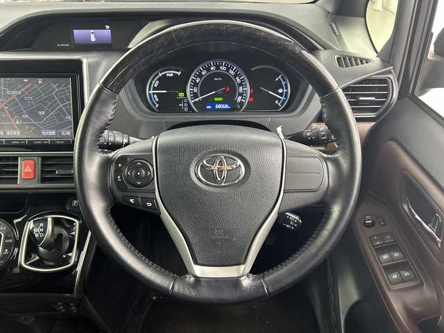 トヨタ エスクァイア ハイブリッド Gi 愛知県 2015(平27)年 6.8万km ブラック 禁煙車/純正9インチナビ/(Bluetooth CD DVD SD FM AM フルセグTV)/ワイヤレス充電/ルーフキャリア/バックカメラ/クルーズコントロール/車両接近通報装置/電動パーキングスイッチ/ビルトインETC/両側パワースライドドア/レザーシート/前席シートヒーター/ナノイー/純正フロアマット/純正15インチアルミホイール/HIDヘッドライト/フロントフォグランプ/Wエアコン/ISO FIX