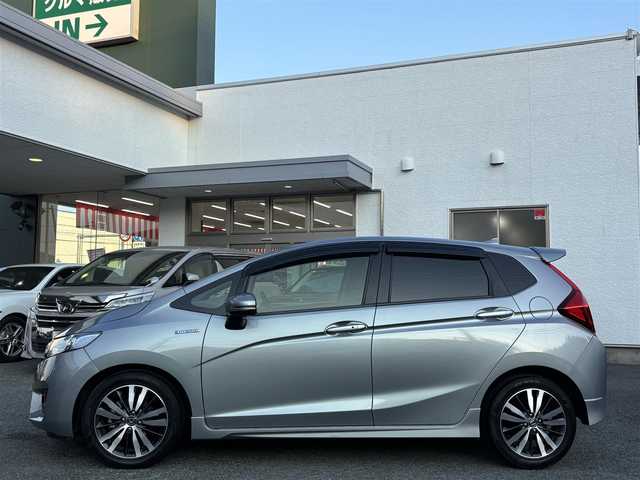 ホンダ フィット ハイブリット Sパッケージ 熊本県 2016(平28)年 6.7万km ティンテッドシルバーM 社外SDナビ(NR-MZ60)/【フルセグTV/SD/CD/DVD/Bluetooth】/バックカメラ/クルーズコントロール/車両接近通報装置/純正16インチアルミホイール/パドルシフト/オートLEDライト/ビルトインETC/横滑り防止装置/盗難防止装置/純正フロアマット/カーテンエアバッグ/プッシュスタート/スマートキー/スペアキー/取扱説明書/保証書