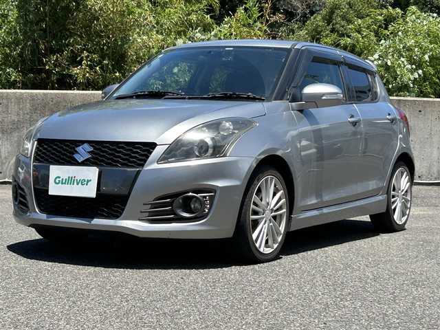 スズキ スイフト スポーツ 長崎県 2013(平25)年 5.1万km プレミアムシルバーメタリック 社外HDDナビ(FM/AM/BT/CD/DVD)/プッシュスタート/スマートキー/スペアキー(1本)/追従機能無しクルーズコントロール/ETC/バックカメラ/MTモード付AT/パドルシフト/ステアリングリモコン/前方ドラレコ/MonsterSport マフラー/ペダルカバー/フロアマット/純正17インチアルミホイール/ABS/ESP/オートライト/SRSダブルエアバッグ/フォグランプスイッチ/取扱説明書/保証書/記録簿/ナビ取扱説明書