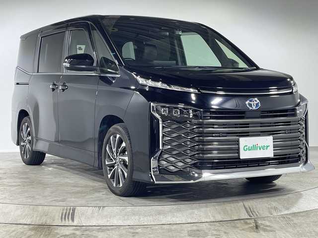 トヨタ ヴォクシー ハイブリッド S－Z 福岡県 2022(令4)年 2万km アティチュードブラックマイカ 純正ナビ/フルセグ/（AM/FM/CD/BT/HDMI）/バックカメラ/追従型クルーズコントロール/ビルトインETC2.0/フリップダウンモニター/D/Nシートヒーター/両側パワースライド/オートホールド/三眼LEDヘッドライト/横滑り防止装置/衝突軽減システム/レーンアシスト/コーナーセンサー/前後ドラレコ/ドアバイザー/プッシュスタート/スマートキー/純正AW17インチ