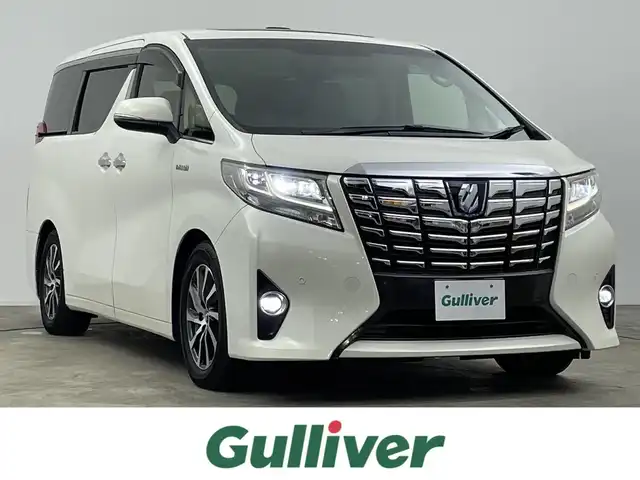 トヨタ アルファードハイブリット エグゼクティブ ラウンジ 千葉県 2016(平28)年 6.7万km ラグジュアリーホワイトパールクリスタルシャインガラスフレーク 禁煙車/４WD/トヨタセーフティセンス/・クリアランスソナー/・プリクラッシュセーフティブレーキ/・クルーズコントロール/JBLプレミアムサウンド/両側パワースライドドア/パワーバックドア/ツインサンルーフ/12.1型フリップダウンモニター/純正９型ディスプレイオーディオナビ/・CD/DVD/USB/AUX/HDMI/Bluetooth/フルセグTV/・バックカメラ/・ビルトインETC/革巻きステアリング/・ステアリングスイッチ/100V電源/レザーシート/・DNセカンドパワーシート/・D席メモリ付き/・DNシートヒーター/・オットマン/電子パーキング/・ブレーキホールド/社外フロアマット/純正１７インチAW/オートライト/・LEDヘッドライト/・LEDフォグランプ