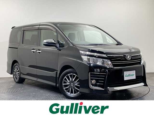 トヨタ ヴォクシー ZS 煌 愛媛県 2015(平27)年 11.4万km ブラック ALPINE10型ナビ/フルセグ　Bluetooth DVD再生可/ALPINE後席フリップダウンモニター/クルーズコントロール//ワンタッチスイッチ付パワースライドドア（両側）/LEDフロントフォグランプ/LEDクリアランスランプ（メッキエクステンション）/LEDルームランプ（フロントパーソナル・センター・リヤ）/フードモール（中央：メッキ、上:ブラック、下：メッキ）/レザー調シートカバー/Toyota Safety Sense C/（・プリクラッシュセーフティシステム/ （レーザーレーダー＋単眼カメラ方式）/・レーンディパーチャーアラート/・オートマチックハイビーム）/専用エアロパーツ（フロント大型バンパー［メッキ加飾付］/＋フロントフェンダー＋リヤ大型バンパー＋リヤスポイラー＋大型サイドマッドガード