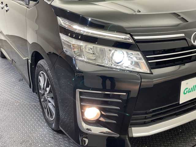 トヨタ ヴォクシー ZS 煌 愛媛県 2015(平27)年 11.4万km ブラック ALPINE10型ナビ/フルセグ　Bluetooth DVD再生可/ALPINE後席フリップダウンモニター/クルーズコントロール//ワンタッチスイッチ付パワースライドドア（両側）/LEDフロントフォグランプ/LEDクリアランスランプ（メッキエクステンション）/LEDルームランプ（フロントパーソナル・センター・リヤ）/フードモール（中央：メッキ、上:ブラック、下：メッキ）/レザー調シートカバー/Toyota Safety Sense C/（・プリクラッシュセーフティシステム/ （レーザーレーダー＋単眼カメラ方式）/・レーンディパーチャーアラート/・オートマチックハイビーム）/専用エアロパーツ（フロント大型バンパー［メッキ加飾付］/＋フロントフェンダー＋リヤ大型バンパー＋リヤスポイラー＋大型サイドマッドガード