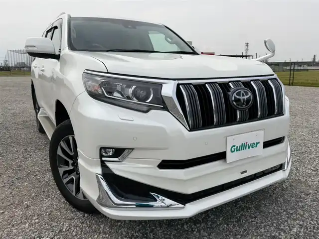 トヨタ ランドクルーザー プラド TX Lパッケージ 愛知県 2023(令5)年 5.1万km ホワイトパールクリスタルシャイン ワンオーナー/4WD/純正9型ナビ(BT/CD/DVD)/フルセグTV/バックカメラ/ビルトインETC/レーダークルーズコントロール/クリアランスソナー/セーフティセンス/・プリクラッシュセーフティ/・レーンディパーチャーアラート/・オートマチックハイビーム/・ロードサインアシスト/LEDヘッドランプ/木目調/革巻きコンビステアリング/ニュートラルベージュ革シート/前席パワーシート/快適温熱シート/3列目電動格納シート/純正19インチアルミホイール/スマートエントリー/スタートシステム/モデリスタエアロ/禁煙車