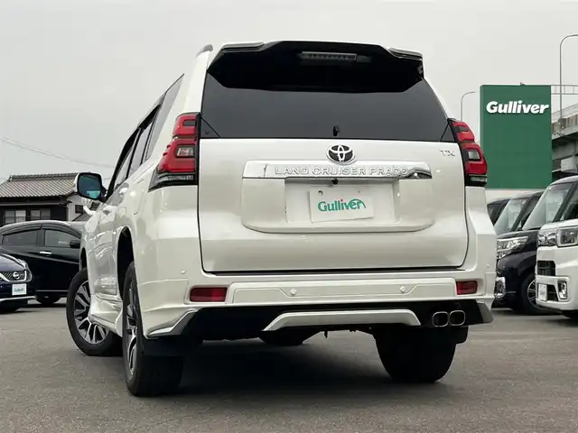 トヨタ ランドクルーザー プラド TX Lパッケージ 愛知県 2023(令5)年 5.1万km ホワイトパールクリスタルシャイン 4WD/純正9型ナビ(BT/CD/DVD)/フルセグTV/バックカメラ/ビルトインETC/レーダークルーズコントロール/クリアランスソナー/セーフティセンス/・プリクラッシュセーフティ/・レーンディパーチャーアラート/・オートマチックハイビーム/・ロードサインアシスト/LEDヘッドランプ/木目調/革巻きコンビステアリング/ニュートラルベージュ革シート/前席パワーシート/快適温熱シート/3列目電動格納シート/純正19インチアルミホイール/スマートエントリー/スタートシステム/モデリスタエアロ