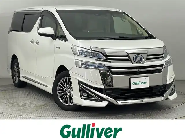 トヨタ ヴェルファイア ハイブリット エグゼクティブ ラウンジ 道央・札幌 2018(平30)年 11.1万km ホワイトパールクリスタルシャイン ・４WD/・寒冷地仕様/・モデリスタエアロ（F・S・R）/・JBLサウンド/・純正メーカーナビ/　CD／DVD／BT／フルセグ/・パノラミックビューモニター/・純正フリップダウンモニター/・デジタルインナーミラー/・純正ビルトインETC2.0/・社外ドライブレコーダー/・両側パワースライドドア/・トヨタセーフティセンス/・プリクラッシュセーフティ/・オートマチックハイビーム/・レーンキープアシスト/・レーントレーシングアシスト/・リヤクロストラフィックアラート/・パーキングサポートブレーキ/・ロードサインアシスト/・アダプティブフロントライティングシステム/・前後コーナーセンサー/・ベージュレザーシート/・全席シートヒーター/・全席シーエアコン/・全席パワーシート/・運転席シートメモリー/・純正AW17インチ/・LEDヘッドライト/・フォグライト/・純正フロアマット/・ドアバイザー/・スマートキー/・プッシュスタート/・スペアキー/・取扱説明書