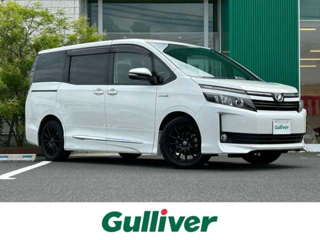トヨタ ヴォクシー ハイブリッド V 岡山県 2015(平27)年 9.7万km ホワイトパールクリスタルシャイン 純正7インチナビ NSZT-W64T/フルセグTV、CD、DVD、Bluetooth、AM、FM/バックカメラ/ミラー一体型ドライブレコーダー/ワイヤレス充電/リアオートエアコン/前席シートヒーター/革調シートカバー/片側パワースライドドア/ビルトインETC/クルーズコントロール/GPSレーダー探知機/オートライト/革巻きステアリング