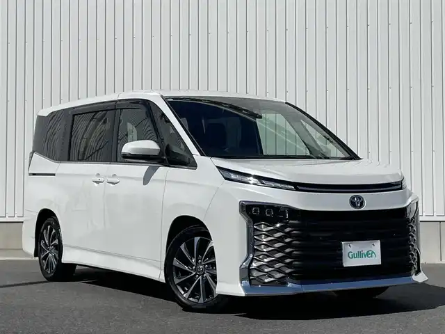トヨタ ヴォクシー S－Z 群馬県 2022(令4)年 0.9万km ホワイトパールクリスタルシャイン 純正10.5インチディスプレイオーディオ/（ナビ/CD/DVD/SD/HDMI/Miracast）/フルセグテレビ/バックカメラ/純正14インチフリップダウンモニター/セーフティセンス/・プリクラッシュセーフティ/・レーンディパーチャーアラート/・オートマチックハイビーム/・ドライバー異常時対応システム/・発信遅れ告知機能/・レーントレーシングアシスト/・レーダークルーズコントロール/・ロードサインアシスト/・プロアクティブドライビングアシスト/パーキングサポートブレーキ/バックドアイージークローザー/両側パワースライドドア/ハーフレザーシート/シートヒーター/オートホールド/プッシュスタート/ビルトインETC/ドライブレコーダー