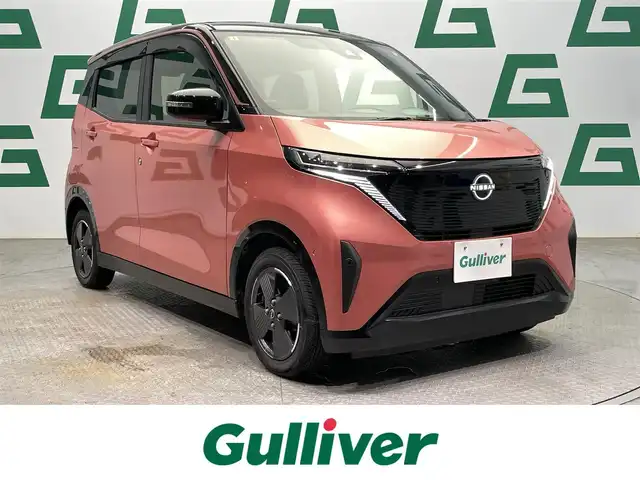 日産 サクラ X 鹿児島県 2023(令5)年 2.7万km ピンク 禁煙車　/社外ディスプレイオーディオ　/(Bluetooth/DVD/CD)　/バックカメラ/エマージェンシーブレーキ/踏み間違い衝突防止アシスト/車線逸脱防止支援システム/標識検知機能/先行車発進お知らせ/コーナーセンサー　/電動パーキングブレーキ　/オートホールド　/スマートキー　/プッシュスタート　/LEDヘッドライト　/純正アルミホイール/純正フロアマット/カラーコード：X42P59