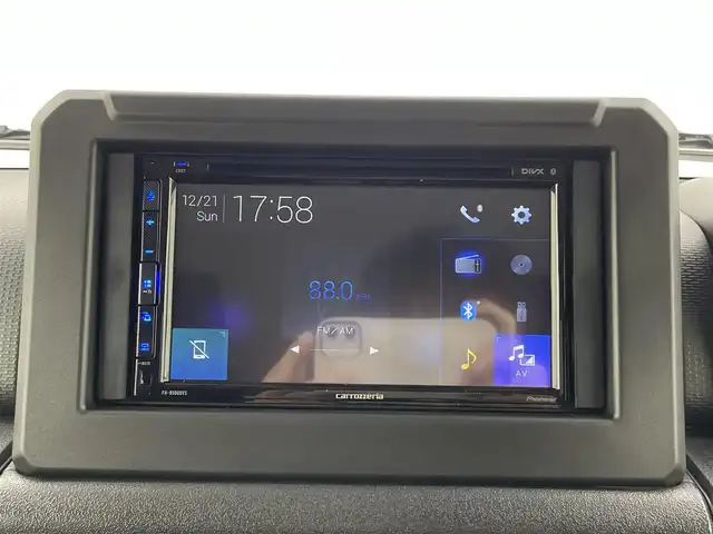 スズキ ジムニー XC 大分県 2025(令7)年 0.1千km ミディアムグレー スズキセーフティサポート　/(クルーズコントロール/誤発進抑制機能/後方誤発進抑制機能/低速時ブレーキサポート/パーキングセンサー/車線逸脱抑制機能/ふらつき警報機能/発進お知らせ機能/標識認識機能)/社外ディスプレイ（Ｂｌｕｅｔｏｏｔｈ　ＣＤ　ラジオ）/禁煙車　/ETC/シートヒーター　/ステアリングスイッチ　/コーナーセンサー　/オートハイビーム/純正16インチアルミホイール/パートタイム４WD/ヒーテッドドアミラー/LEDヘッドライト/アイドリングストップ/ワンオナー