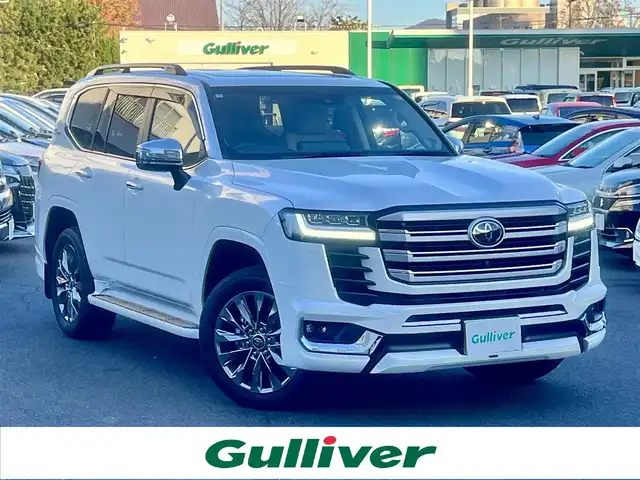 トヨタ ランドクルーザー ZX 島根県 2024(令6)年 1.2万km プレシャスホワイトパール ワンオーナー　/モデリスタエアロ（フロント／リア／リアアンダー）　/サンルーフ　/ＪＢＬサウンドシステム　/ベージュレザーシート/純正１２．３インチメモリナビ　/（フルセグTV／ＤＶＤ再生／Ｂｌｕｅｔｏｏｔｈ接続）　/後席ヘッドレストモニター×２/全方位／バックカメラ　/デジタルインナーミラー（後方録画機能付き）/前方ドライブレコーダー　/ビルトインETC２．０　/Toyota Safety Sense/・プリクラッシュセーフティ/・レーントレーシングアシスト/・レーンディパーチャーアラート/・レーダークルーズコントロール/・アダプティブハイビームシステム／オートマチックハイビーム/・ロードサインアシスト/・ドライバー異常時対応システム/・発進遅れ告知機能/ブラインドスポットモニター　/ヘッドアップディスプレイ/パワーバックドア/運転席メモリーパワーシート＋助手席パワーシート/全席シートヒーター／エアシート/ステアリングヒーター/COOL BOX/純正２０インチアルミホイール/保証書・取扱説明書（本体＋ナビ）・スペアキー1本/社外セキュリティー （Grgo）