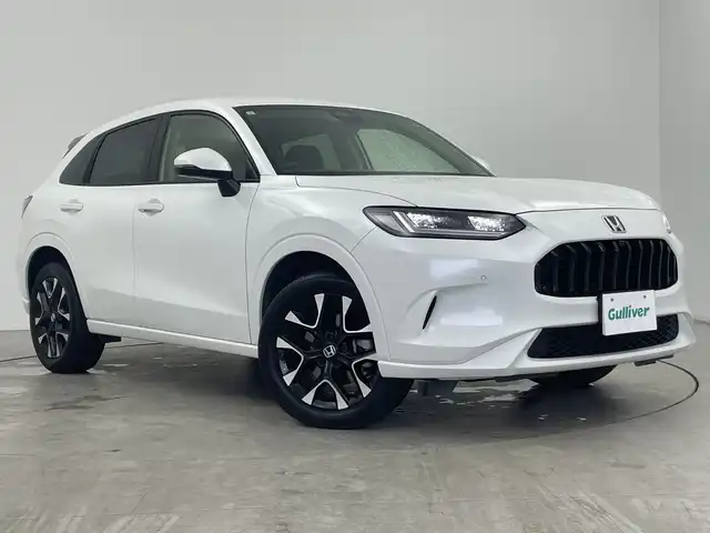 ホンダ ＺＲ－Ｖ ハイブリッド e:HEV Z 三重県 2023(令5)年 2.9万km プラチナホワイトパール Honda SENSING/●衝突軽減ブレーキ（CMBS）/●先行車発進お知らせ機能/●歩行者事故低減ステアリング/●路外逸脱抑制機能/●標識認識機能/●渋滞追従機能付アダプティブクルーズコントロール（ACC）/●車線維持支援システム（LKAS）/●トラフィックジャムアシスト（渋滞運転支援機能）/●ブラインドスポットインフォメーション/●誤発進抑制機能/●後方誤発進抑制機能/●近距離衝突軽減ブレーキ/●パーキングセンサーシステム/●後退出庫サポ―と/●アダプティブドライビングビーム/マルチビューカメラシステム/9型Honda CONNECTディスプレー/・ナビ/フルセグ/BT/スマホ連携/USB/ETC2.0車載器/ワイヤレス充電器/前後ドラレコ（DRH-224SD）/本革シート/D/Nパワーシート/運転席＆助手席シートヒーター/BOSEプレミアムサウンドシステム(12スピーカー)/ハンズフリーアクセスパワーテールゲート(予約クローズ機能付)/18インチアルミホイール(切削＋ベルリナブラック)/注：BSI後退出庫サポートレス
