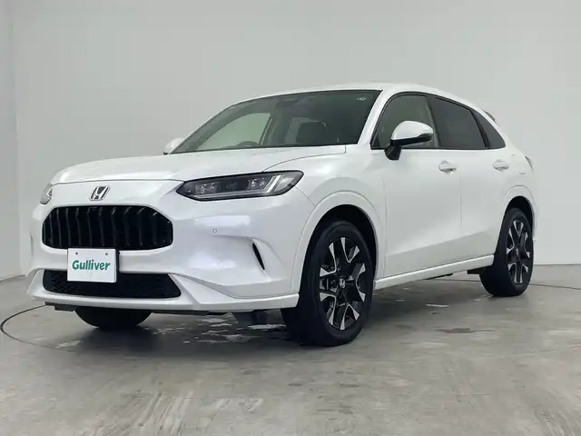 ホンダ ＺＲ－Ｖ ハイブリッド e:HEV Z 三重県 2023(令5)年 2.9万km プラチナホワイトパール Honda SENSING/●衝突軽減ブレーキ（CMBS）/●先行車発進お知らせ機能/●歩行者事故低減ステアリング/●路外逸脱抑制機能/●標識認識機能/●渋滞追従機能付アダプティブクルーズコントロール（ACC）/●車線維持支援システム（LKAS）/●トラフィックジャムアシスト（渋滞運転支援機能）/●ブラインドスポットインフォメーション/●誤発進抑制機能/●後方誤発進抑制機能/●近距離衝突軽減ブレーキ/●パーキングセンサーシステム/●後退出庫サポ―と/●アダプティブドライビングビーム/マルチビューカメラシステム/9型Honda CONNECTディスプレー/・ナビ/フルセグ/BT/スマホ連携/USB/ETC2.0車載器/ワイヤレス充電器/前後ドラレコ（DRH-224SD）/本革シート/D/Nパワーシート/運転席＆助手席シートヒーター/BOSEプレミアムサウンドシステム(12スピーカー)/ハンズフリーアクセスパワーテールゲート(予約クローズ機能付)/18インチアルミホイール(切削＋ベルリナブラック)/注：BSI後退出庫サポートレス