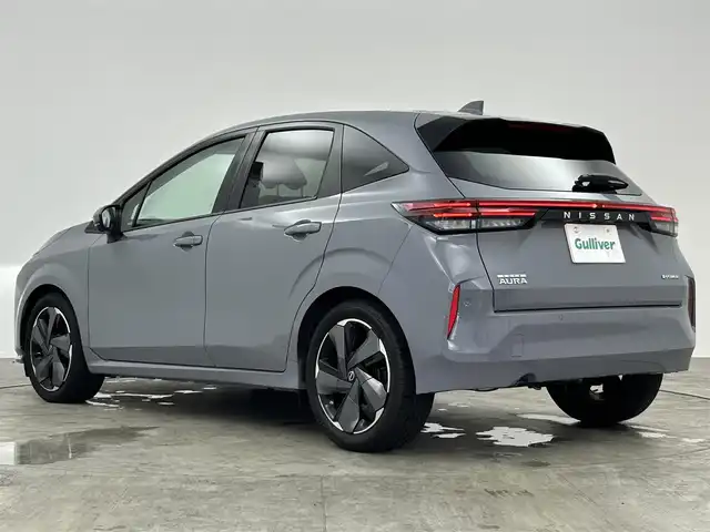 日産 オーラ G レザーエディション 愛知県 2024(令6)年 0.7万km グレー ・禁煙車　/・純正ナビMM223D-L（フルセグ・ＢＴ・ＵＳＢ）/・全周囲カメラ　/・ＥＴＣ　/・前後クリアランスソナー　/・インテリジェントエマージェンシーブレーキ/・踏み間違い防止　/・車線逸脱防止支援システム　/・車線逸脱警報/・ふらつき警報　/・標識認識機能/・後側方衝突防止支援システム/・後側方車両検知警報/・後退車両検知警報/・オートマチックハイビーム/・ブラインドスポットモニター/・横滑り防止/・デジタルインナーミラー/・オートライト/・LEDヘッドライト/・フォグライト/・スマートキー/・プッシュスタート