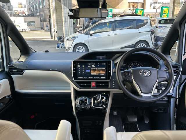 トヨタ ノア ハイブリッド Si ダブルバイビー 埼玉県 2018(平30)年 8.4万km ホワイトパールクリスタルシャイン 登録時84070km/ワンオーナー/純正メモリナビ（NSZN-Z68T）/フルセグ/CD/DVD/BT/バックカメラ/衝突被害軽減ブレーキ/レーンキープアシスト/横滑り防止装置/クルーズコントロール/純正フリップダウンモニター（V12T-R68C）/EV MODE/ECO MODE/PWR MODE/ドライブレコーダー（ZDR-013）/ビルトインETC2.0/シートヒーター（D＋N席）/両側パワースライドドア/プッシュスタート/オートライト/オートマチックハイビーム/電動格納ミラー/ウィンカーミラー/革巻きハンドル/純正フロアマット/LEDヘッドライト/フォグ/純正16インチアルミホイール/ドアバイザー/スマートキー×2/保証書/取説/ナビ取説