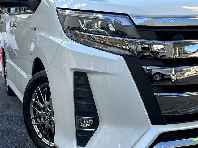 トヨタ ノア ハイブリッド Si ダブルバイビー 埼玉県 2018(平30)年 8.4万km ホワイトパールクリスタルシャイン 登録時84070km/ワンオーナー/純正メモリナビ（NSZN-Z68T）/フルセグ/CD/DVD/BT/バックカメラ/衝突被害軽減ブレーキ/レーンキープアシスト/横滑り防止装置/クルーズコントロール/純正フリップダウンモニター（V12T-R68C）/EV MODE/ECO MODE/PWR MODE/ドライブレコーダー（ZDR-013）/ビルトインETC2.0/シートヒーター（D＋N席）/両側パワースライドドア/プッシュスタート/オートライト/オートマチックハイビーム/電動格納ミラー/ウィンカーミラー/革巻きハンドル/純正フロアマット/LEDヘッドライト/フォグ/純正16インチアルミホイール/ドアバイザー/スマートキー×2/保証書/取説/ナビ取説