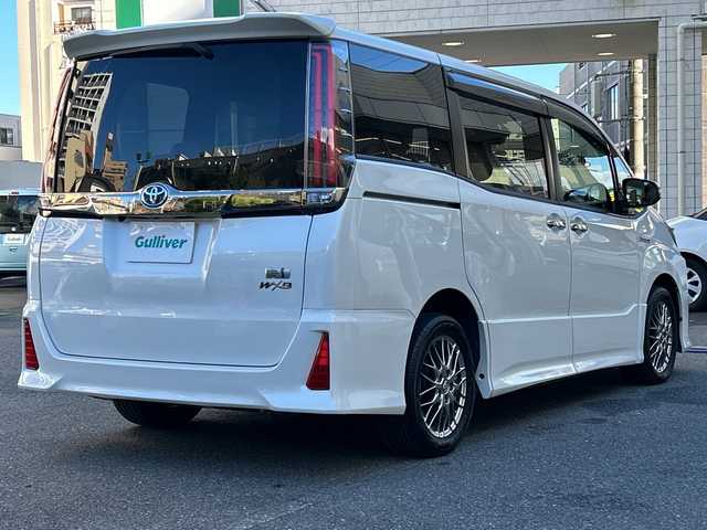 トヨタ ノア ハイブリッド Si ダブルバイビー 埼玉県 2018(平30)年 8.4万km ホワイトパールクリスタルシャイン 登録時84070km/ワンオーナー/純正メモリナビ（NSZN-Z68T）/フルセグ/CD/DVD/BT/バックカメラ/衝突被害軽減ブレーキ/レーンキープアシスト/横滑り防止装置/クルーズコントロール/純正フリップダウンモニター（V12T-R68C）/EV MODE/ECO MODE/PWR MODE/ドライブレコーダー（ZDR-013）/ビルトインETC2.0/シートヒーター（D＋N席）/両側パワースライドドア/プッシュスタート/オートライト/オートマチックハイビーム/電動格納ミラー/ウィンカーミラー/革巻きハンドル/純正フロアマット/LEDヘッドライト/フォグ/純正16インチアルミホイール/ドアバイザー/スマートキー×2/保証書/取説/ナビ取説