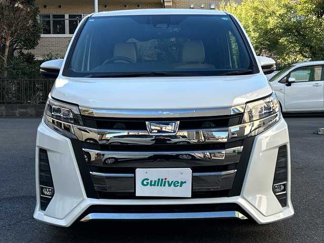 トヨタ ノア ハイブリッド Si ダブルバイビー 埼玉県 2018(平30)年 8.4万km ホワイトパールクリスタルシャイン 登録時84070km/ワンオーナー/純正メモリナビ（NSZN-Z68T）/フルセグ/CD/DVD/BT/バックカメラ/衝突被害軽減ブレーキ/レーンキープアシスト/横滑り防止装置/クルーズコントロール/純正フリップダウンモニター（V12T-R68C）/EV MODE/ECO MODE/PWR MODE/ドライブレコーダー（ZDR-013）/ビルトインETC2.0/シートヒーター（D＋N席）/両側パワースライドドア/プッシュスタート/オートライト/オートマチックハイビーム/電動格納ミラー/ウィンカーミラー/革巻きハンドル/純正フロアマット/LEDヘッドライト/フォグ/純正16インチアルミホイール/ドアバイザー/スマートキー×2/保証書/取説/ナビ取説