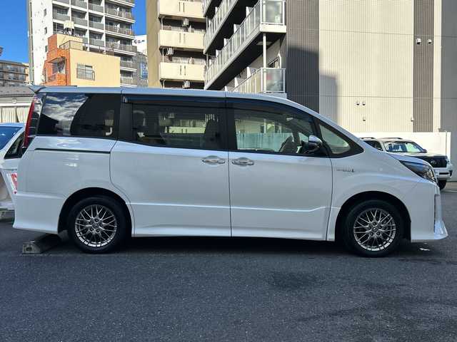 トヨタ ノア ハイブリッド Si ダブルバイビー 埼玉県 2018(平30)年 8.4万km ホワイトパールクリスタルシャイン 登録時84070km/ワンオーナー/純正メモリナビ（NSZN-Z68T）/フルセグ/CD/DVD/BT/バックカメラ/衝突被害軽減ブレーキ/レーンキープアシスト/横滑り防止装置/クルーズコントロール/純正フリップダウンモニター（V12T-R68C）/EV MODE/ECO MODE/PWR MODE/ドライブレコーダー（ZDR-013）/ビルトインETC2.0/シートヒーター（D＋N席）/両側パワースライドドア/プッシュスタート/オートライト/オートマチックハイビーム/電動格納ミラー/ウィンカーミラー/革巻きハンドル/純正フロアマット/LEDヘッドライト/フォグ/純正16インチアルミホイール/ドアバイザー/スマートキー×2/保証書/取説/ナビ取説