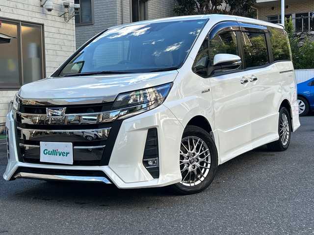 トヨタ ノア ハイブリッド Si ダブルバイビー 埼玉県 2018(平30)年 8.4万km ホワイトパールクリスタルシャイン 登録時84070km/ワンオーナー/純正メモリナビ（NSZN-Z68T）/フルセグ/CD/DVD/BT/バックカメラ/衝突被害軽減ブレーキ/レーンキープアシスト/横滑り防止装置/クルーズコントロール/純正フリップダウンモニター（V12T-R68C）/EV MODE/ECO MODE/PWR MODE/ドライブレコーダー（ZDR-013）/ビルトインETC2.0/シートヒーター（D＋N席）/両側パワースライドドア/プッシュスタート/オートライト/オートマチックハイビーム/電動格納ミラー/ウィンカーミラー/革巻きハンドル/純正フロアマット/LEDヘッドライト/フォグ/純正16インチアルミホイール/ドアバイザー/スマートキー×2/保証書/取説/ナビ取説