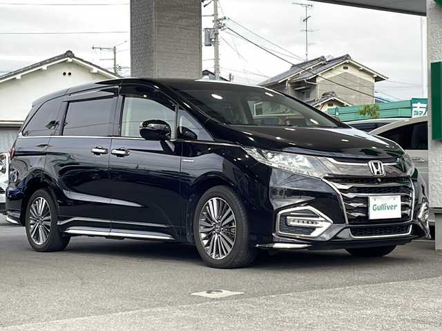 ホンダ オデッセイ ハイブリッド 愛媛県 2018(平30)年 1.8万km クリスタルブラックパール ワンオーナー/純正ナビ(VXM-197VFNI)/・Bluetooth/・フルセグTV/・バックカメラ/・DVD再生/ホンダセンシング/・衝突軽減ブレーキ（CMBS）/・歩行者事故低減ステアリング/・路外逸脱抑制機能/・誤発進抑制機能/・先行車発進お知らせ機能/・標識認識機能/・ACC（アダプティブ・クルーズ・コントロール）/・LKAS（車線維持支援システム）/ETC2.0/ブラインドスポットモニター/パーキングアシスト/両側パワースライドア/3列シート/ハーフレザーシート/前席シートヒーター/前席パワーシート/キャプテンシート/オットマン/純正ドライブレコーダー/オートマチックブレーキホールド/LEDヘッドライト