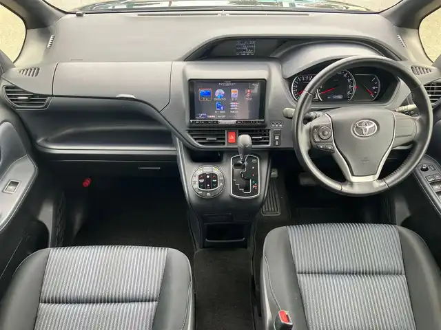 トヨタ ヴォクシー ZS 静岡県 2015(平27)年 5.3万km ブラック エンジンスタートボタン/パワーステアリング/パワーウィンドウ/アイドリングストップ/スマートキー/スペアキー/Wオートエアコン/フリップダウンモニター/ETC/バックカメラ/9インチナビ(CD/DVD/BT/フルセグ)/3列シート/チップアップシート/純正フロアマット/左側パワースライドドア/右側スライドドア/純正アルミホイール/ABS/横滑り防止装置/オートライト/LEDヘッドライト/Wエアバック