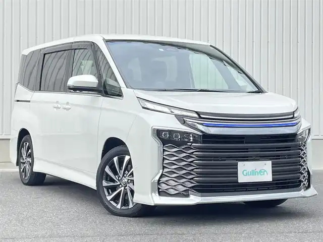 トヨタ ヴォクシー S－Z 群馬県 2023(令5)年 1.3万km ホワイトパールクリスタルシャイン 純正10.5インチディスプレイオーディオ/（ナビ/CD/DVD/HDMI/USB/フルセグテレビ）/純正14インチフリップダウンモニター/セーフティセンス/・プリクラッシュセーフティ/・レーンディパーチャーアラート/・オートマチックハイビーム/・ドライバー異常時対応システム/・発進遅れ告知機能/・レーントレーシングアシスト/・レーダークルーズコントロール/・ロードサインアシスト/・プロアクティブドライビングアシスト/トヨタチームメイト/・アドバンスパーク/・パーキングサポートブレーキ/・パノラミックビューモニター/・ボディ同色ドアミラー/7インチカラーマルチインフォメーションディスプレイ/バックドアイージークローザー/両側パワースライドドア/三眼LEDヘッドランプ/ハーフレザーシート/シートヒーター/センターコンソール/2列目キャプテンシート/2列目充電用USBタイプC端子付サイドテーブル/前後ドライブレコーダー/ETC2.0