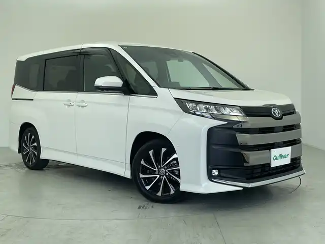トヨタ ノア ハイブリッド 愛知県 2024(令6)年 0.8万km ホワイトパールクリスタルシャイン 純正10型ナビ/・AppleCarPlay/・Bluetooth/・フルセグ/・DVD/・CD/フリップダウンモニター/ETC/パノラマミックビューモニター/前後ドライブレコーダー/両側パワースライドドア/追従型クルコン/ABS/BSM/レーンキープアシスト/横滑り防止装置/イモビライザー/オートライト/オートマチックハイビーム/衝突軽減システム/LEDヘッドライト/純正アルミホイール