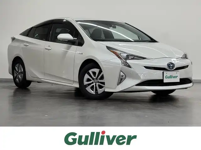 トヨタ プリウス A 三重県 2016(平28)年 10.3万km ホワイトパールクリスタルシャイン ハイブリッド/FF/インパネCVT/純正 9インチナビ DSZT-YC4T/（AM/FM/CD/DVD/SD/SDREC/Bluetooth/TV）/バックガイドモニター/ドライブレコーダー 前方/ビルトイン ETC/Toyota Safety Sense/・プリクラッシュセーフティ/・レーンディパーチャーアラート（ハンドル支援あり）/・レーダークルコン/・オートハイビーム/・インテリジェントクリアランスソナー［巻き込み警報機能付］/・シンプルインテリジェントパーキングアシスト/・【OP】ITS Connect/など/装備/・内装色『クールグレー』/・カラーヘッドアップディスプレイ/・オートライト/・LED ヘッドランプ＆フロントフォグランプ/・【OP】ナビレディセット（バックカメラ、ステアリングスイッチ）/・オートエアコン/・純正15inAW（加飾ホイールカバー付）/・プッシュスタート/・スマートキーx2/・ウインカー付電動格納ドアミラー/・保/など