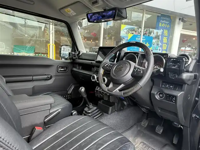 スズキ ジムニー シエラ JC 長崎県 2023(令5)年 0.3万km ブルーイッシュブラックパール3 登録時3017km/社外ナビ/・TV/・Bluetooth/・DVD/バックカメラ/クルーズコントロール/全席シートカバー/アルパインデジタルインナーミラー/メーターパネル交換/社外肘置き/TRUST製ブースト計/BLITZエアクリーナー/社外マフラー/ホワイトレターブロックタイヤ/背面タイヤあり/社外16インチアルミホイール/ボンネット油圧式ダンパー