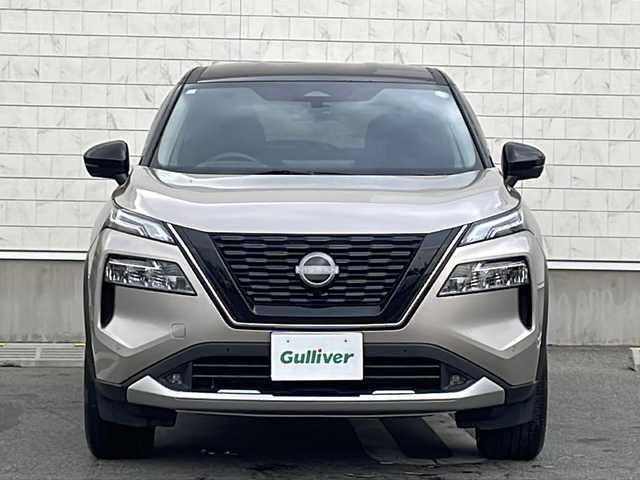 日産 エクストレイル G e－4ORCE 山形県 2023(令5)年 0.7万km シルバー／黒 カラーコード：XEW シェルブロンド / スーパーブラック 2トーン/禁煙車/プロパイロット/後側車両検知警報/衝突回避支援システム/踏み間違い衝突防止アシスト/前方衝突予測警報/横滑り防止装置/ふらつき警報/レーンキープアシスト/合皮シート/ディスプレイオーディオナビ（AM/FM/BT/USB/TV）/フルセグTV/オールアラウンドビューモニター/前後USB＆Type-C　挿込口　有/100V電源/ハンドルヒーター/デジタルインナーミラー/D/N席パワーシート/D席メモリシート/全席シートヒーター/木目調インストロア/本革巻ステアリング/パワーバックドア/ドライブレコーダー前後/コーナーセンサー前後/アダプティブLEDライト/LEDフォグ/ビルトインETC/オートホールド付電子パーキング/置くだけ充電/寒冷地仕様