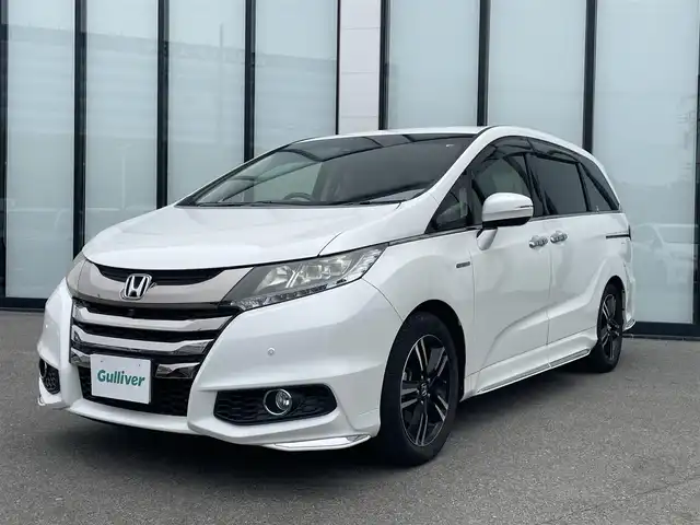 ホンダ オデッセイ ハイブリッド アブソルートセンシングEXパック 大阪府 2016(平28)年 6.6万km ホワイトオーキッドパール 純正ナビ /   TV/CD/DVD/Bluetooth/全方位モニター/後席モニター/衝突軽減ブレーキ/横滑り防止装置/コーナーセンサー/ＢＳＭ/レーダークルーズコントロール/レーンキープアシスト/アイドリングストップ/両側パワースライドドア/オットマン/ハーフレザーシート/純正17インチアルミホイール/純正フロアマット/ＥＴＣ/ＬＥＤライト