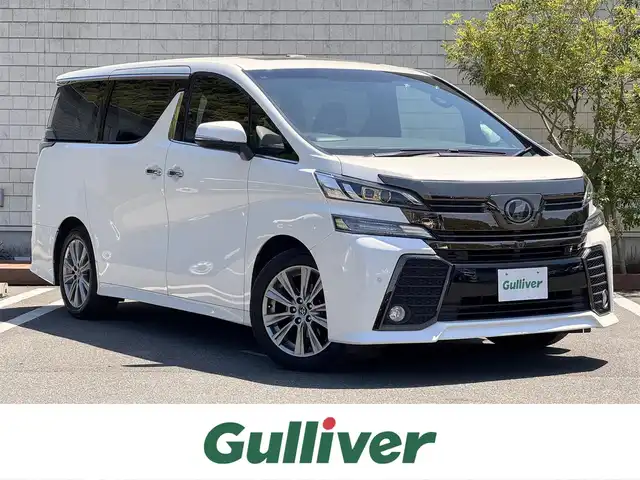 トヨタ ヴェルファイア Z Aエディション 愛媛県 2016(平28)年 3.1万km ホワイトパールクリスタルシャイン サンルーフ/純正フリップダウンモニター/純正メーカーナビ/・Bluetooth/・CD/DVD/・USB端子/フルセグTV/JBLサウンドシステム/パノラミックビューモニター/両側パワースライドドア/パワーバックドア/3列シート/ドライブレコーダー/ETC/100V充電/ハーフレザーシート/純正18インチAW/コーナーセンサー/クルーズコントロール（追従機能有）/オートマチックハイビーム/衝突軽減システム/LEDヘッドライト/スマートキー/スペアキー/取扱説明書/保証書