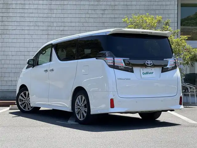トヨタ ヴェルファイア Z Aエディション 愛媛県 2016(平28)年 3.1万km ホワイトパールクリスタルシャイン サンルーフ/純正フリップダウンモニター/純正メーカーナビ/・Bluetooth/・CD/DVD/・USB端子/フルセグTV/JBLサウンドシステム/パノラミックビューモニター/両側パワースライドドア/パワーバックドア/3列シート/ドライブレコーダー/ETC/100V充電/ハーフレザーシート/純正18インチAW/コーナーセンサー/クルーズコントロール（追従機能有）/オートマチックハイビーム/衝突軽減システム/LEDヘッドライト/スマートキー/スペアキー/取扱説明書/保証書