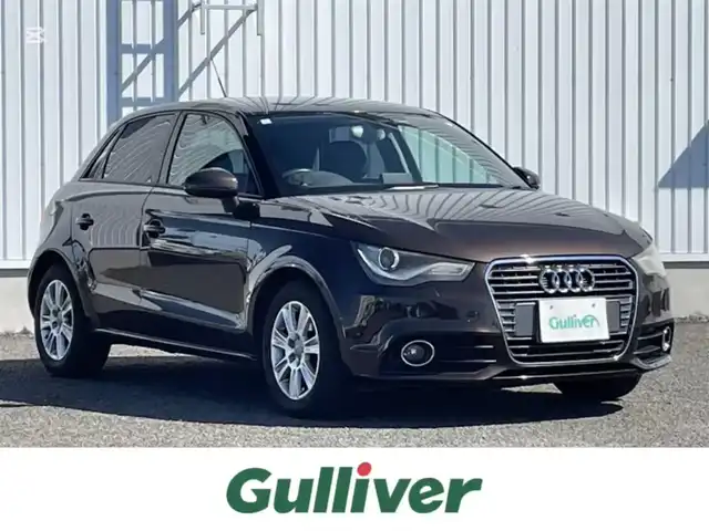 アウディ Ａ１ スポーツバック 1．4TFSI 熊本県 2012(平24)年 10.3万km ティークブラウンメタリック 純正ナビ/・AM/FM/CD/BT/クラッシュセーフティ/スピードオーバー警告機能/横滑り防止装置/シートハイトアジャスター/ビルトインETC/革巻きステアリング/・ステアリングリモコン/HIDヘッドライト/・ヘッドライトウォッシャー/・フォグランプ/電動格納ミラー/・ドアミラーウィンカー/純正フロアマット/純正15インチAW/アイドリングストップ/MTモード付AT/プッシュスタート/・スマートキー/・スペアキー